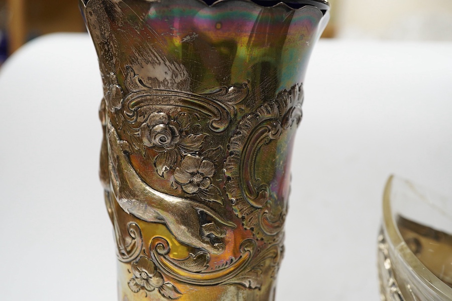 An Edwardian silver vase, embossed with hunting scene, with blue glass liner, Manoah Rhodes & Sons Ltd, London, 1901, 20.7cm, together with a German 800 white metal dish, on three supports. with damaged glass liner, 14.4